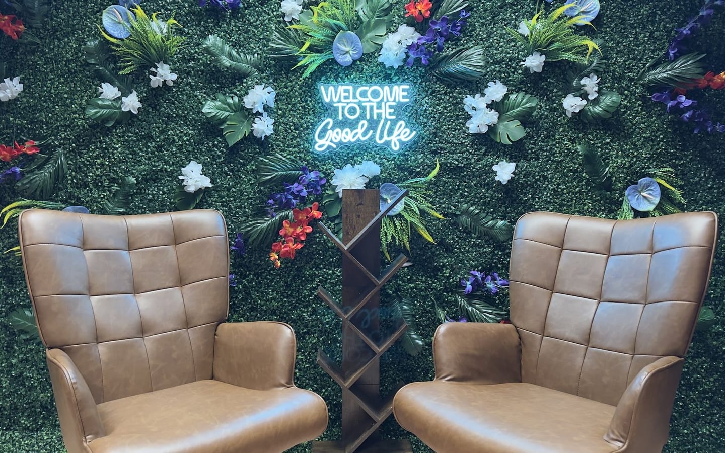 The Good Life: two tufted armchairs in front of a living moss wall