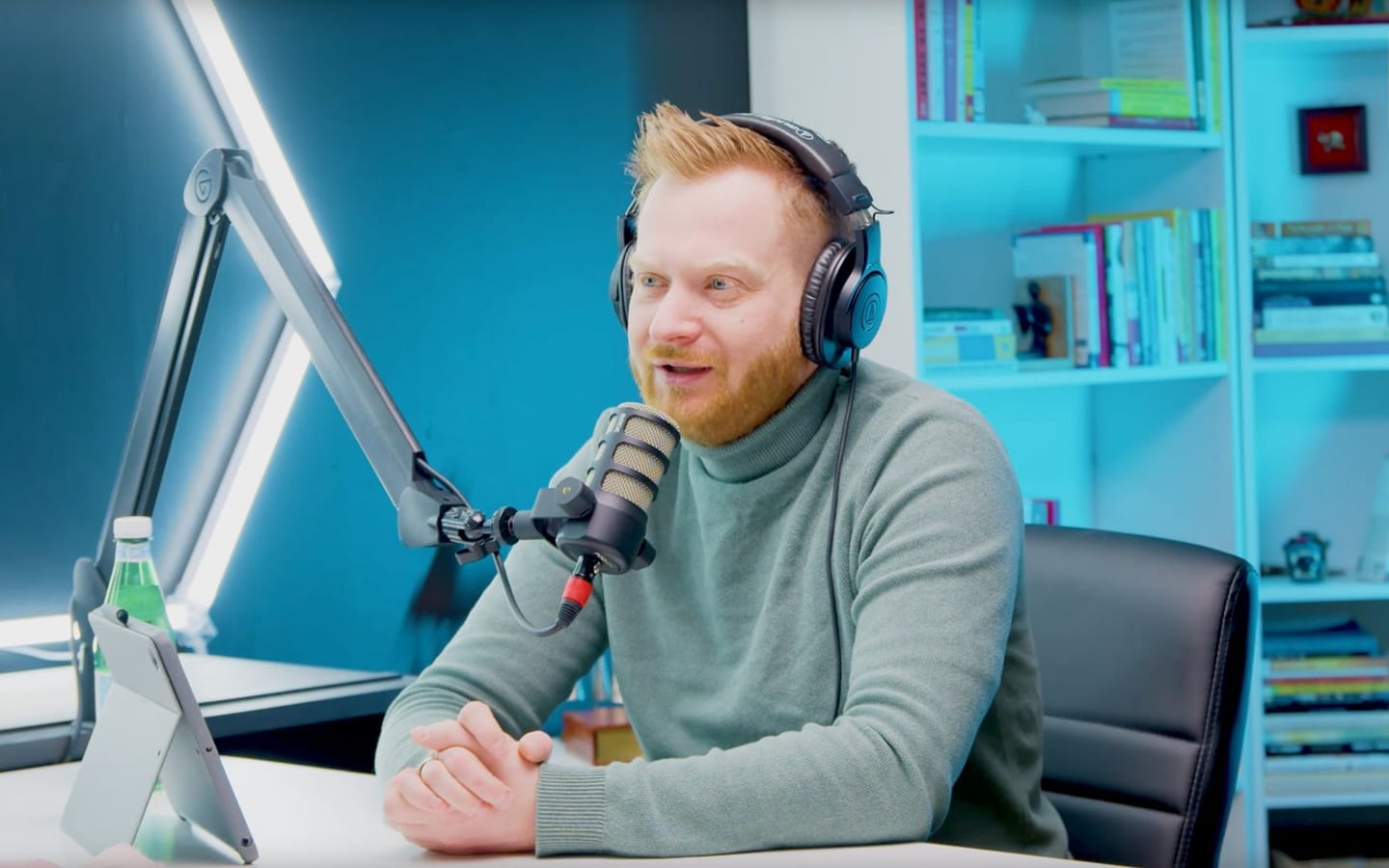 The Screening Room: teal shelving and a white desk under a broadcast light